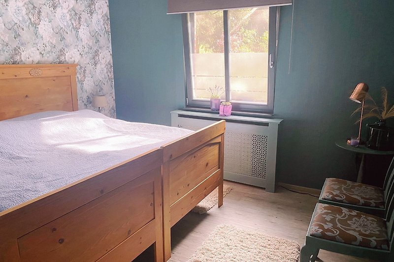 Ein gemütliches Schlafzimmer mit Holzmöbeln und Fensterdekoration.