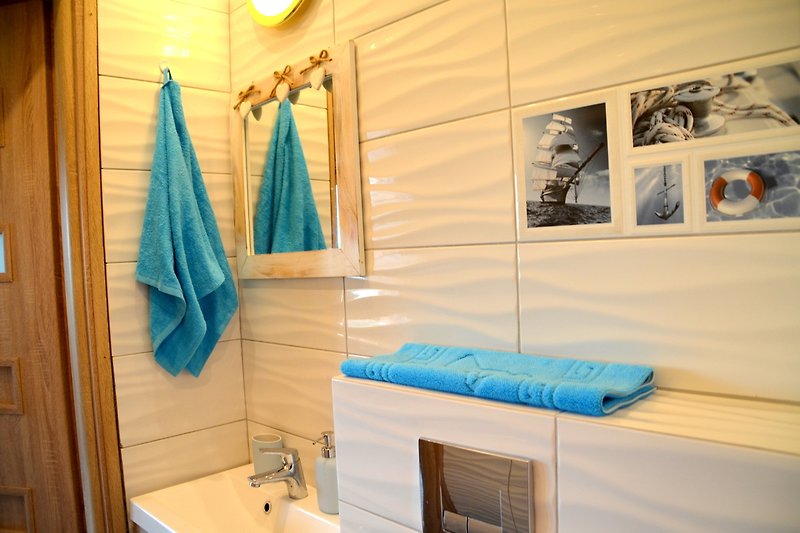 Gemütliches Badezimmer mit Holzboden und blauen Vorhängen.