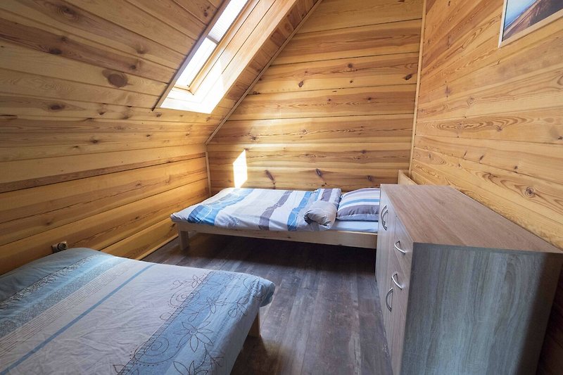 Gemütlicher Dachboden mit Holzbalken und Holzboden.