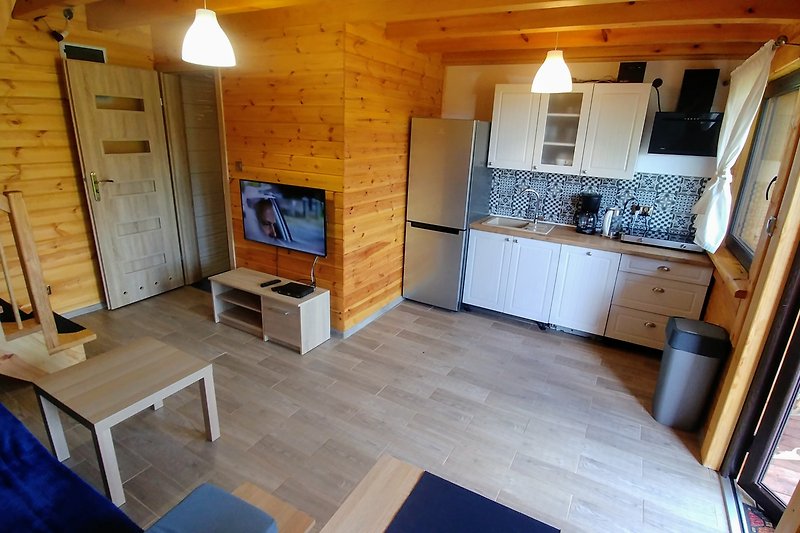 Schönes Wohnzimmer mit Holzboden, Küche und modernen Geräten.