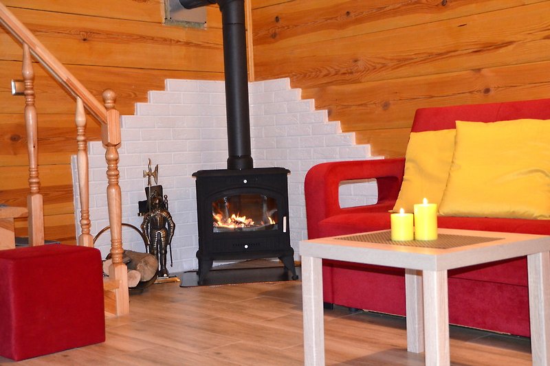 Gemütliches Wohnzimmer mit Holzmöbeln und Kaminfeuer.