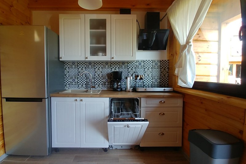 Moderne Küche mit Holzschränken, Arbeitsplatte und Spülbecken.