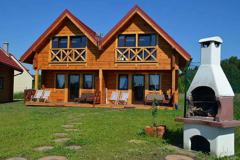 Holzhaus mit grünem Dach und Fenster.