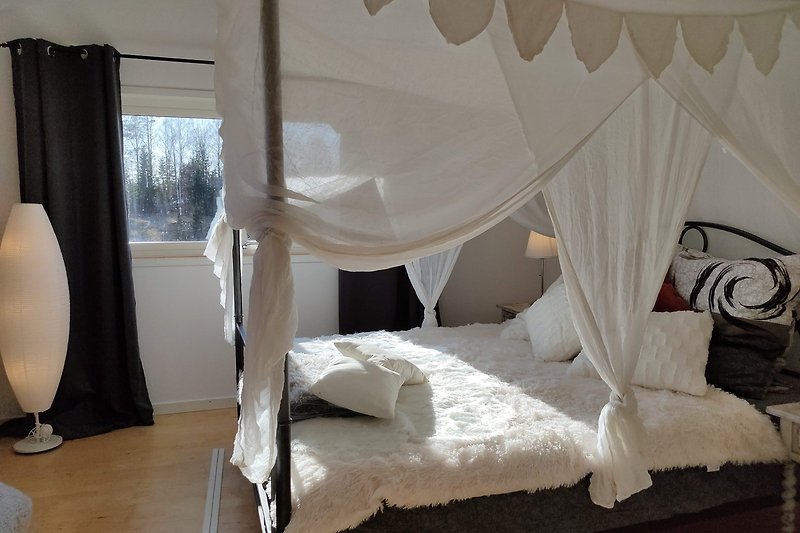 Komfortables Schlafzimmer mit stilvoller Einrichtung und Moskitonetz.
