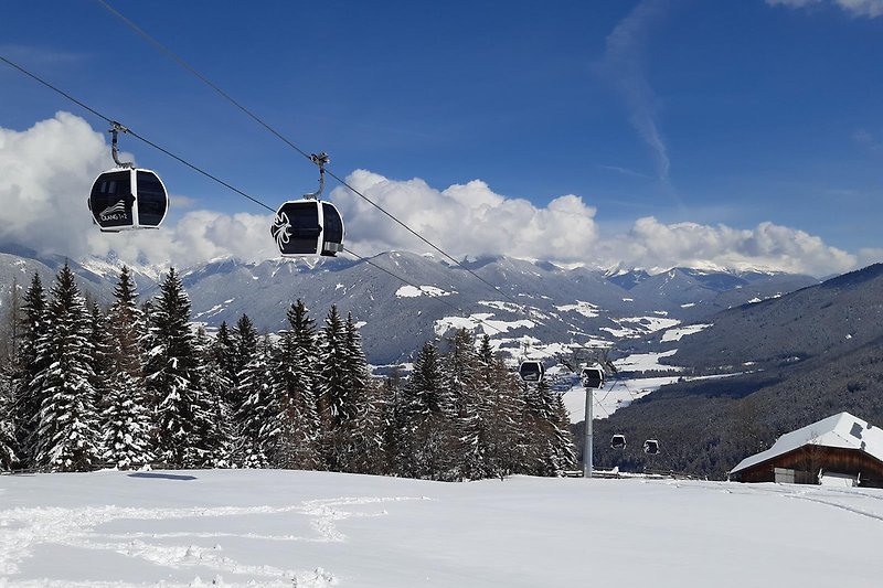 Verschneite Berge mit Seilbahn und Skigebiet im Winter.