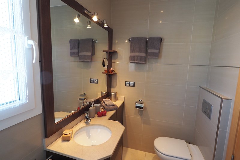 Ein modernes Badezimmer mit elegantem Waschbecken zugehörig zu dem Masterschlafzimmer
