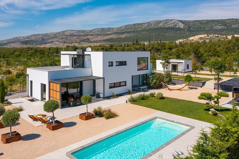 A stunning property with a swimming pool, mountain views, and lush landscaping.