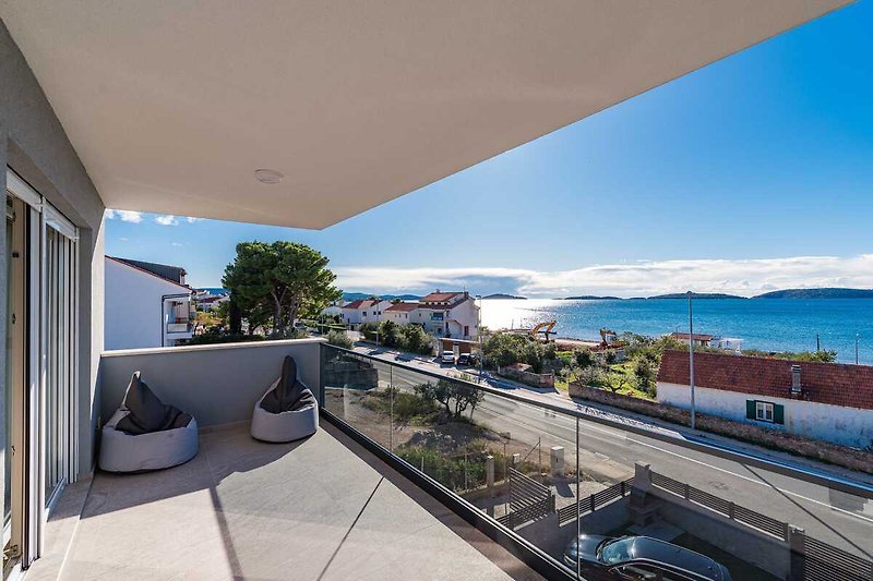 A modern seaside resort with a stunning ocean view and outdoor furniture.