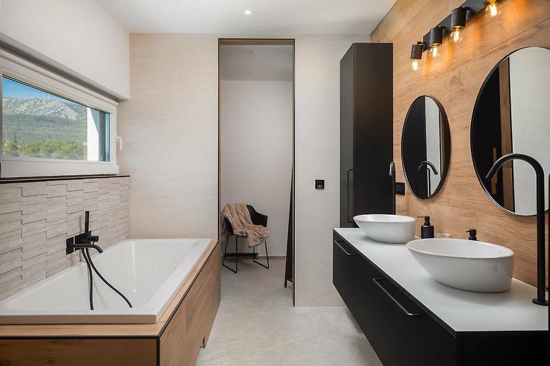 A stylish bathroom with a sleek mirror, tap, and elegant sink.