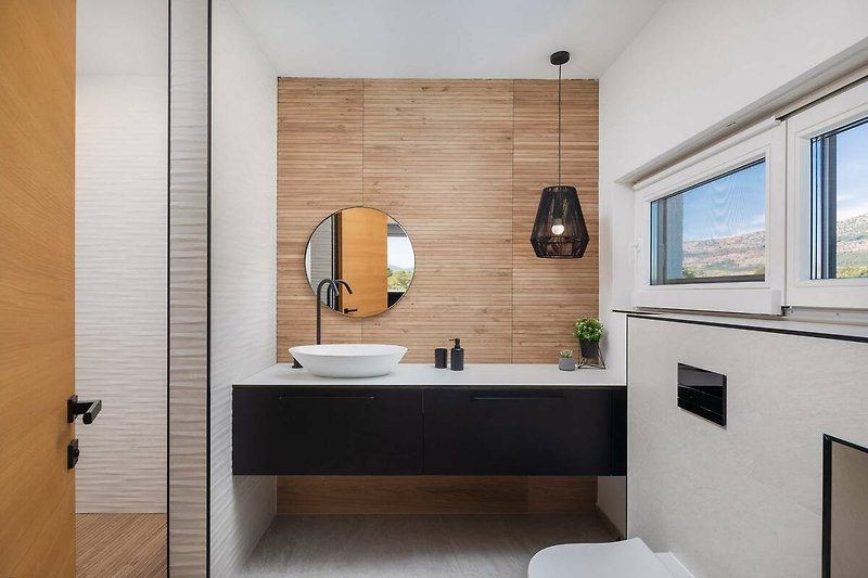 A modern bathroom with a sleek mirror, tap, and stylish sink.