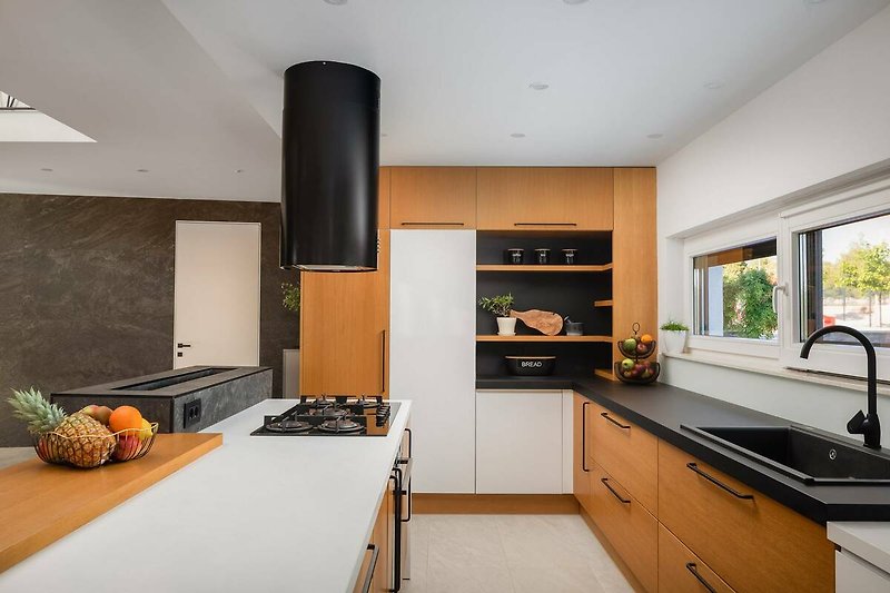 A modern kitchen with sleek cabinetry, a granite countertop, and a gas stove.