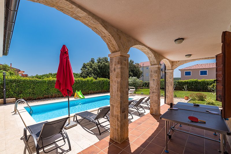 A stylish outdoor area with comfortable furniture and a refreshing swimming pool.