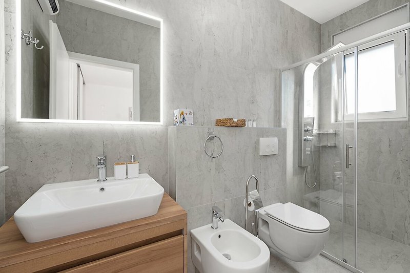 A modern bathroom with a sleek sink, elegant fixtures, and a mirror.