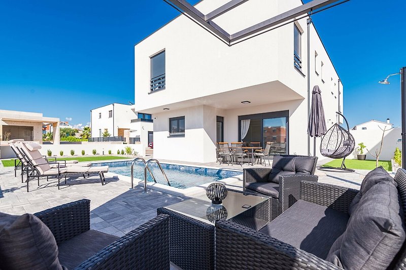 A stylish outdoor area with a swimming pool and comfortable furniture.