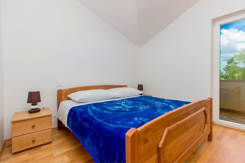 Gemütliches Schlafzimmer mit Holzmöbeln und blauem Himmel.