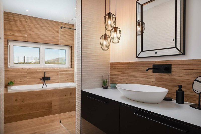 A stylish bathroom with a sleek mirror, tap, and elegant sink.