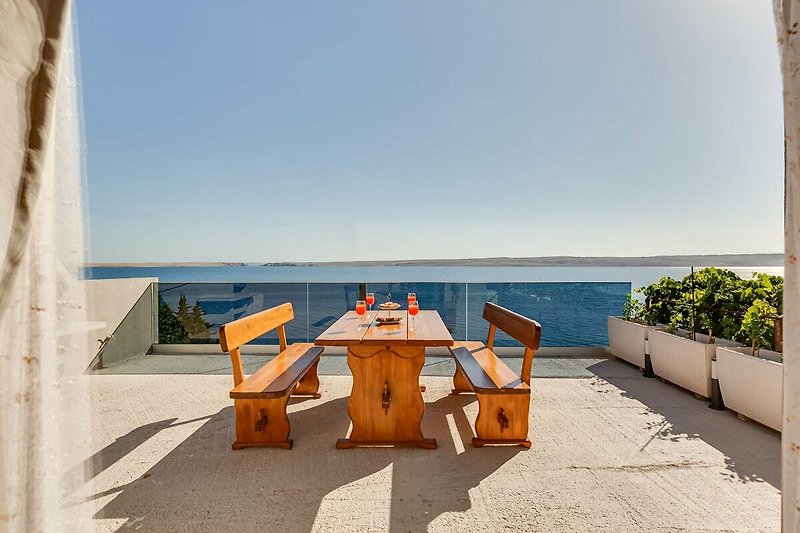 A beachfront property with outdoor furniture and a stunning view of the ocean.