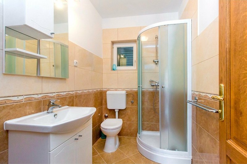 Schönes Badezimmer mit lila Duschtür und Holzwaschtisch.