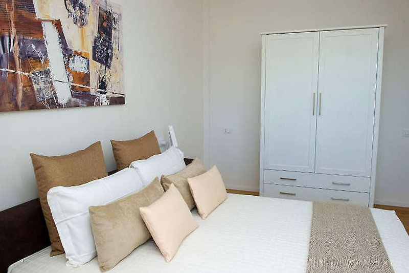 Gemütliches Schlafzimmer mit Holzmöbeln und Kunst an der Wand.