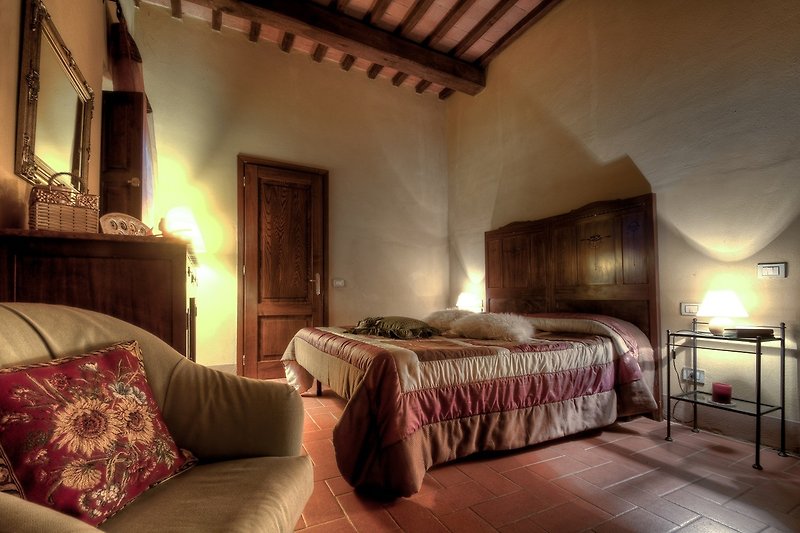 Gemütliches Schlafzimmer mit elegantem Himmelbett und stilvoller Beleuchtung.