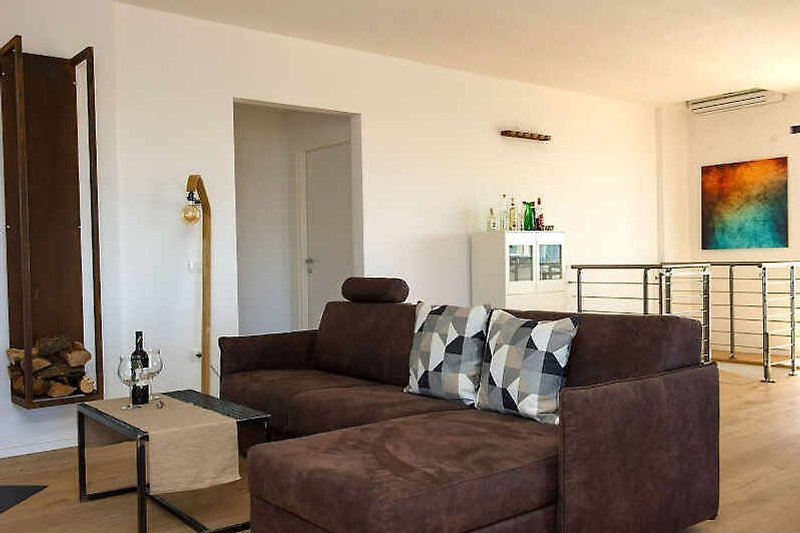 Gemütliches Wohnzimmer mit Holzmöbeln, gemütlicher Couch und Kunstdruck.