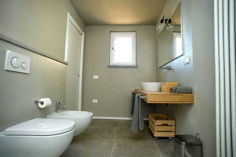 Schönes Badezimmer mit Fenster, Waschbecken und Toilette.