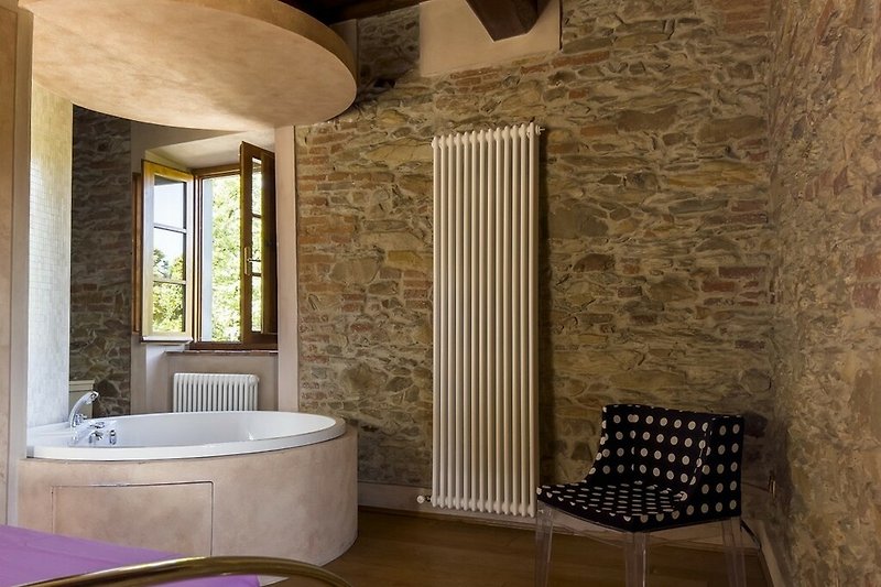 Gemütliches Badezimmer mit Holzboden und stilvollem Fenster.
