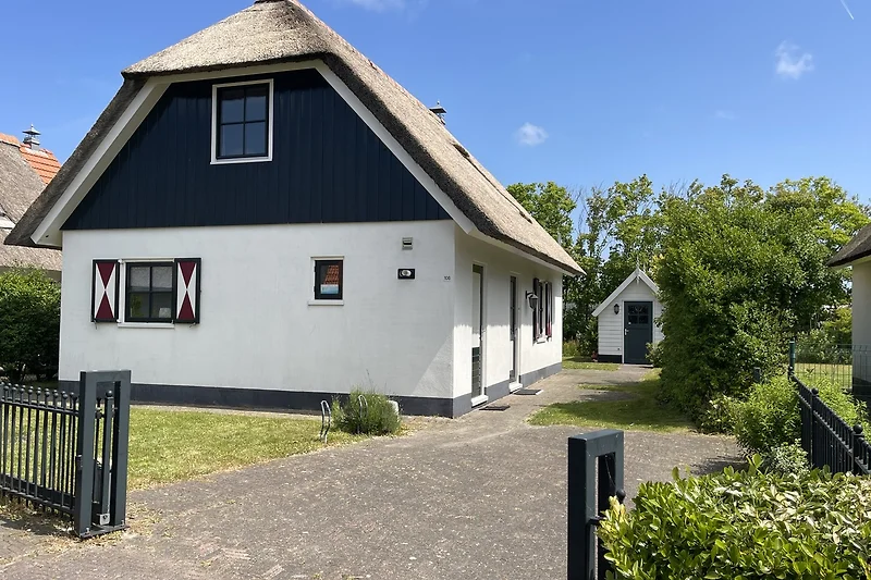 Prachtig huis met een rieten dak en een mooie tuin.