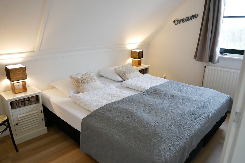Stijlvolle slaapkamer met houten meubels en sfeervolle verlichting.