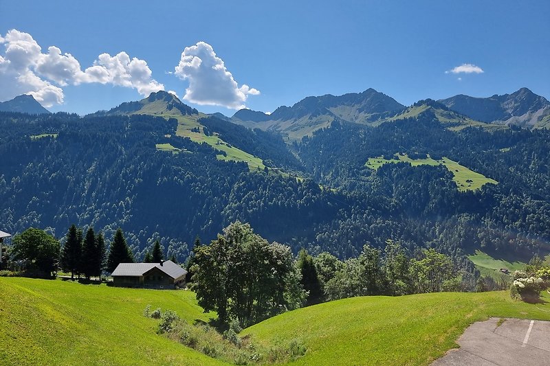 Ein malerisches Bergdorf mit grünen Wiesen und majestätischen Gipfeln.