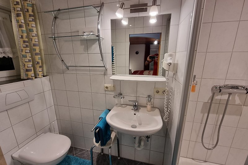 Kinder-Badezimmer mit Spiegel, Waschbecken und Toilette.