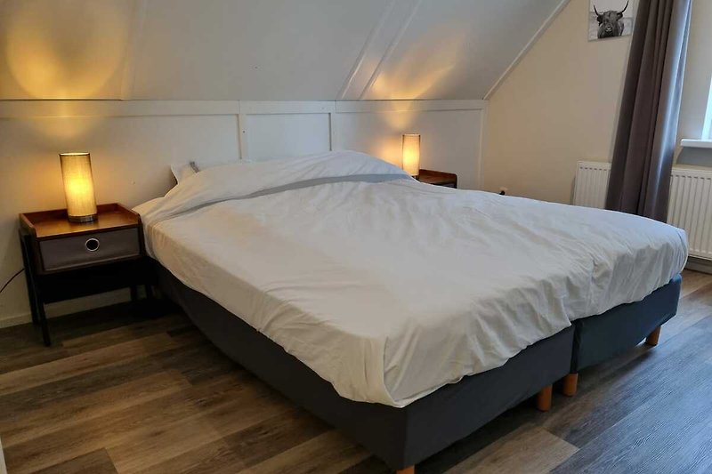 Een comfortabele slaapkamer met houten meubels en een gezellige lamp.