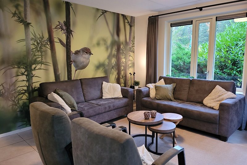 Een sfeervol interieur met comfortabele meubels en een prachtig uitzicht op de tuin.