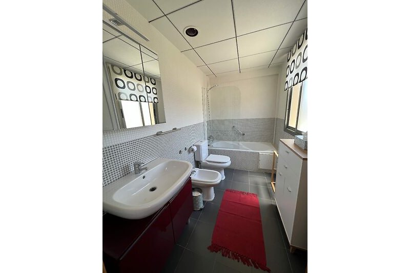 Modernes Badezimmer mit stilvoller Beleuchtung, Spiegel und Wasserhahn.