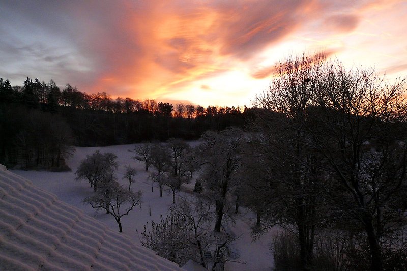 Sonnenaufgang über einer verschneiten Landschaft.