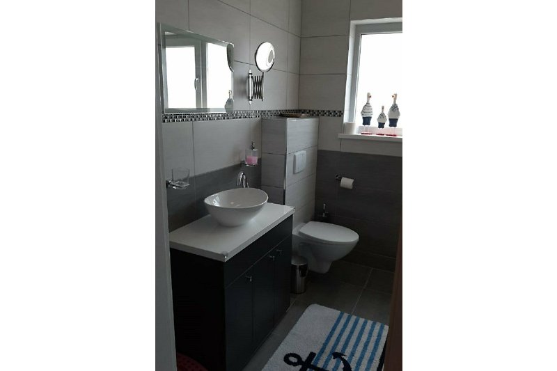 Badezimmer mit Waschbecken, Seifenspender, Spiegel mit stilvoller Beleuchtung, zusätzlich Kosmetikspiegel & Waage