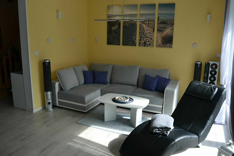 Gemütliches Wohnzimmer mit bequemer Couch und einem Ruhesessel