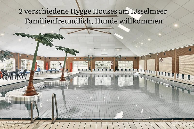 Verschneiter Poolbereich im Resort mit Blick auf das winterliche Dorf.