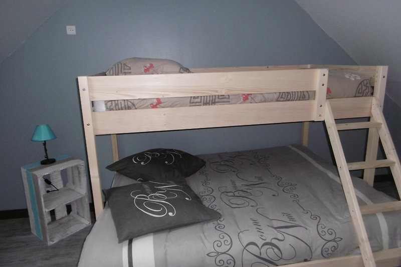 Chambre confortable avec lit superposé en bois et linge de lit doux.