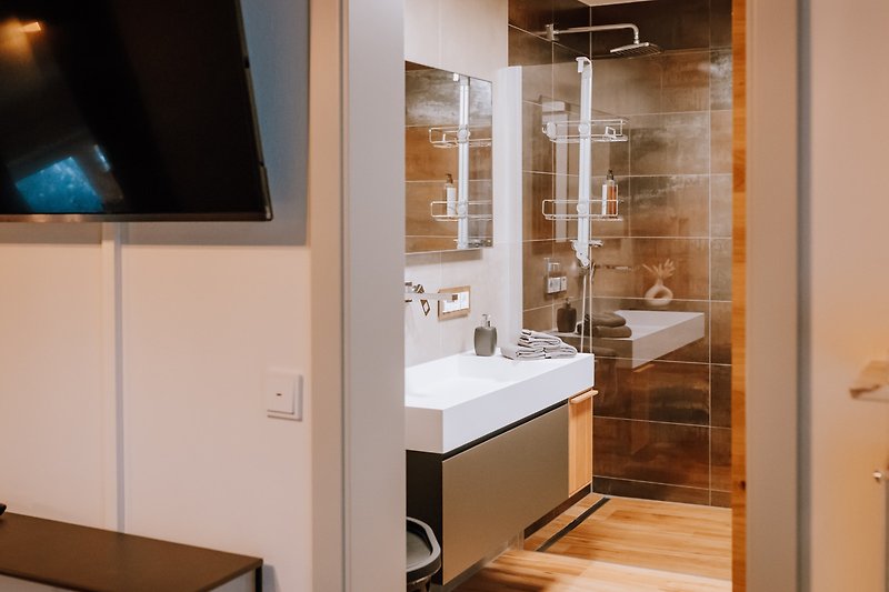 Stilvolles Badezimmer mit Spiegel, Waschbecken und moderner Ausstattung.