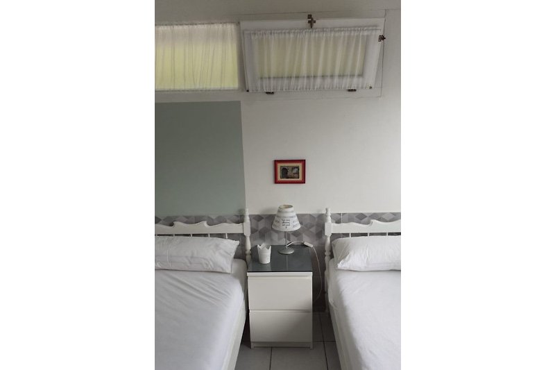 Schlafzimmer mit zwei Einzelbetten. Kissen und Decken vorhanden