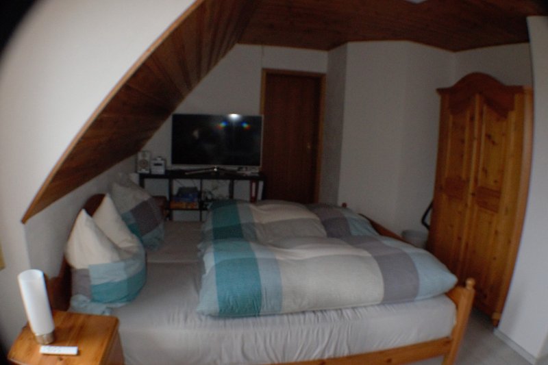 Gemütliches Schlafzimmer mit Holzbett, bequemer Matratze und stilvollem Interieur.