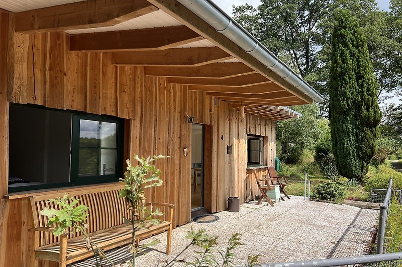 Schönes Holzhaus mit Terrasse und Garten.