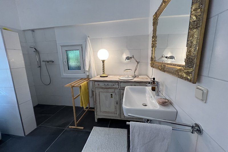 Schönes Badezimmer mit Spiegel, Waschbecken und Armatur.