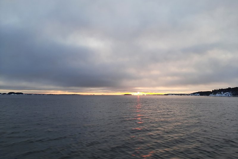 Stunning sunset over a tranquil lake with a beautiful coastline. Taken from departure from Stavsnäs.