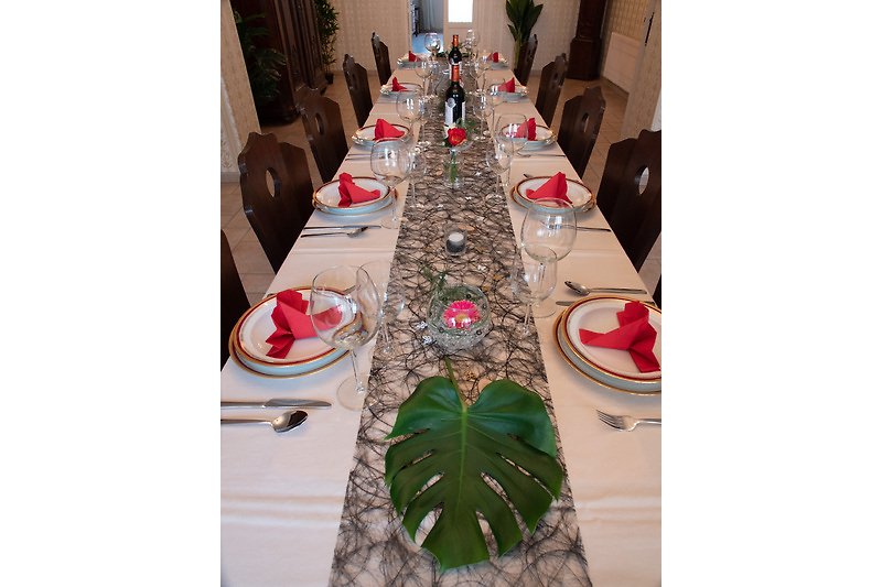 Table élégante avec vaisselle, verres et décoration florale.