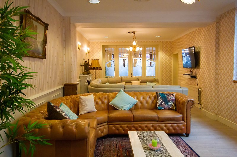 Salon confortable avec table basse, canapé, décoration et éclairage chaleureux.