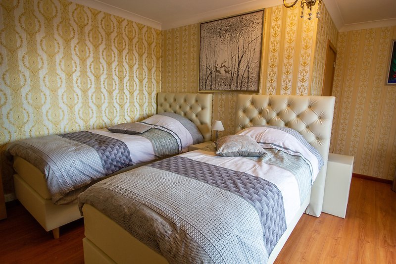 Chambre confortable avec lit douillet, oreillers moelleux et décoration chaleureuse.