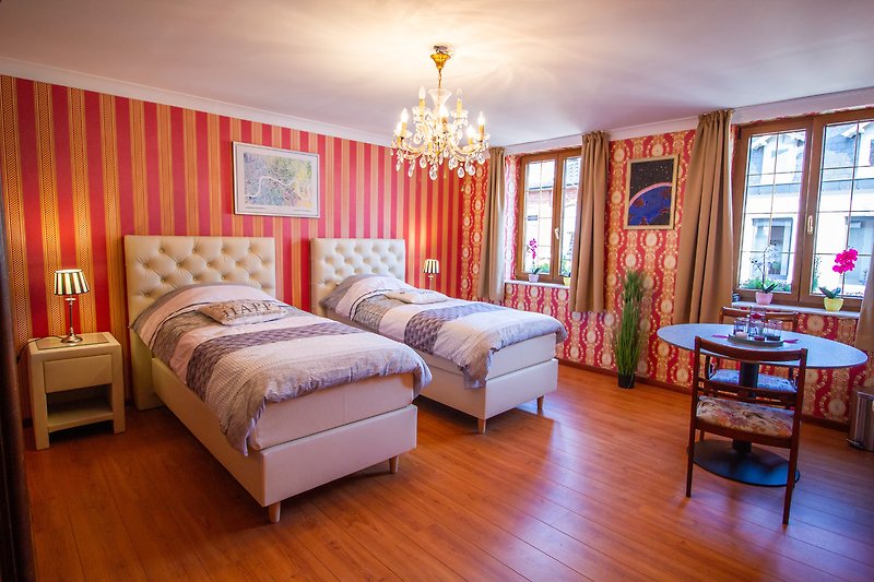 Chambre lumineuse avec lit confortable et décoration chaleureuse.