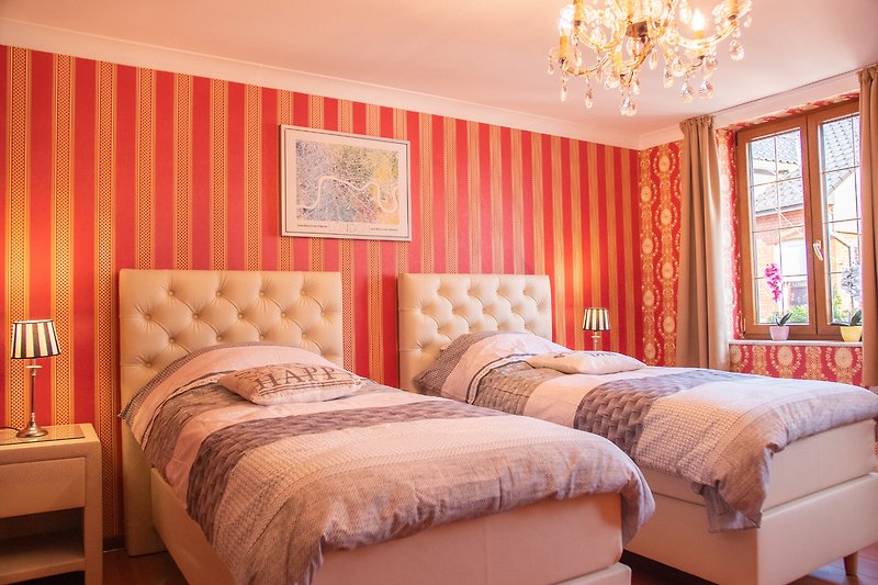 Elegantes Schlafzimmer mit Holzmöbeln, orangefarbenen Akzenten und stilvoller Beleuchtung.